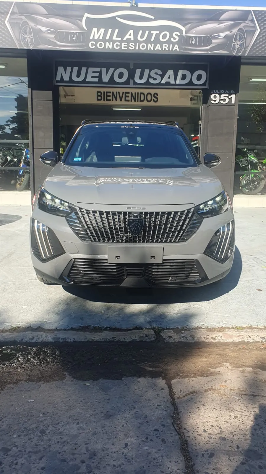 Frente de Mil Autos en Julio A. Roca 951, con el cartel de Nuevo Usado y un Peugeot 2008 en la vereda